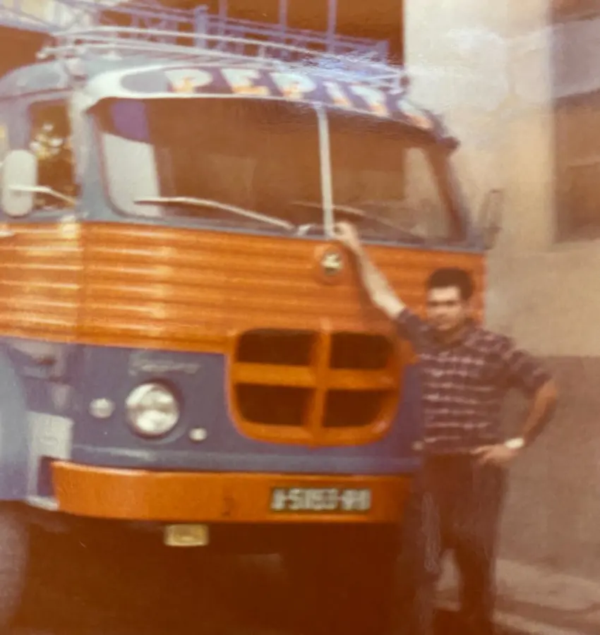 Camión clásico naranja con una persona junto a la cabina