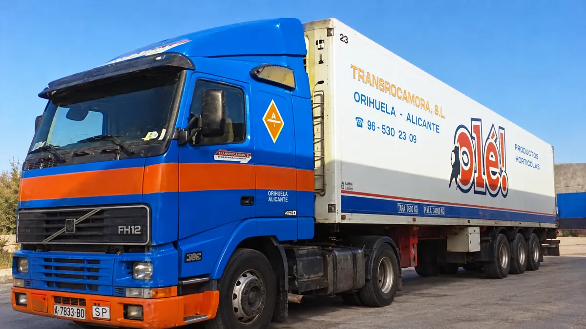 Camión Volvo azul con semirremolque frigorífico rotulado
